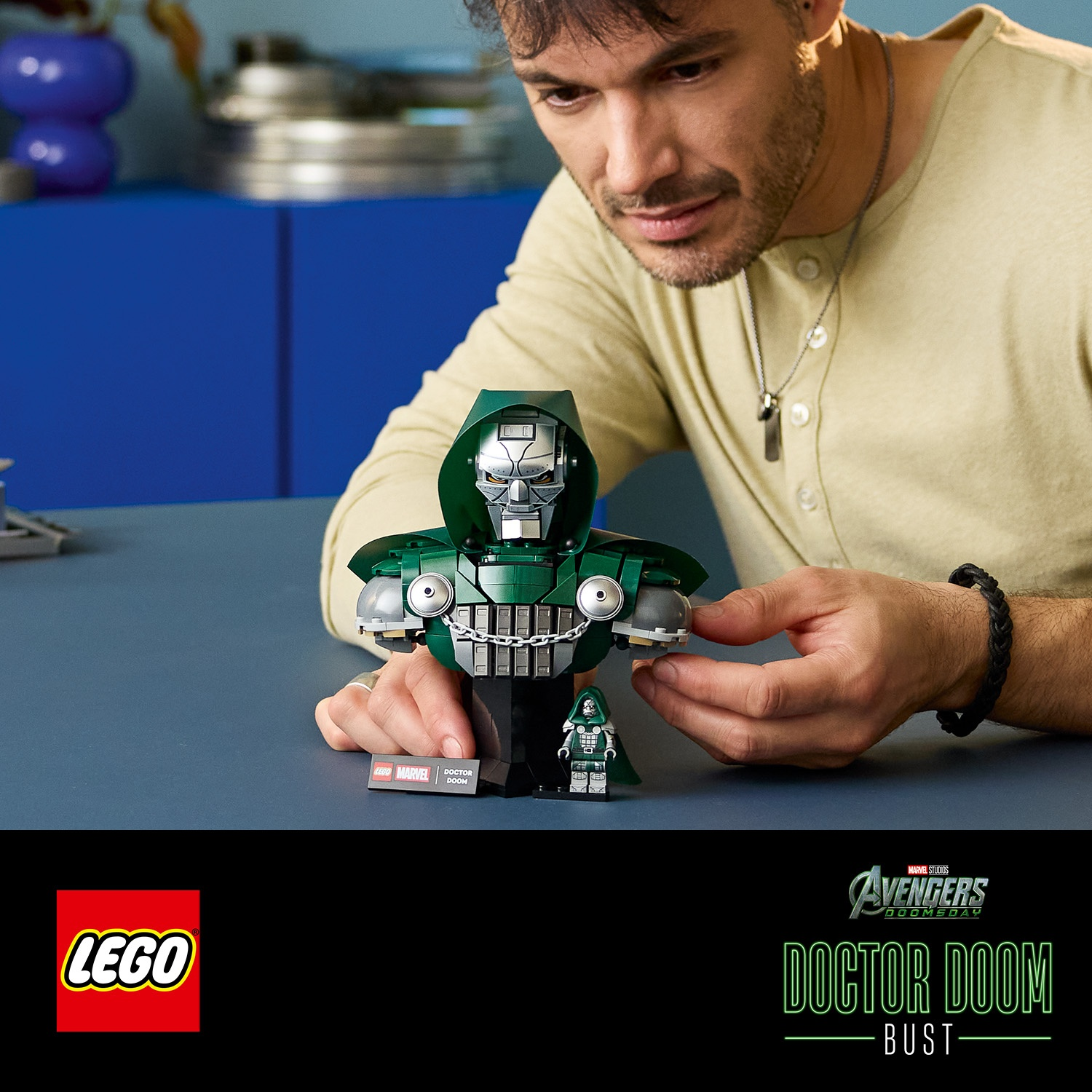 Un uomo costruisce un busto Lego Marvel Doctor Doom con minifigura.