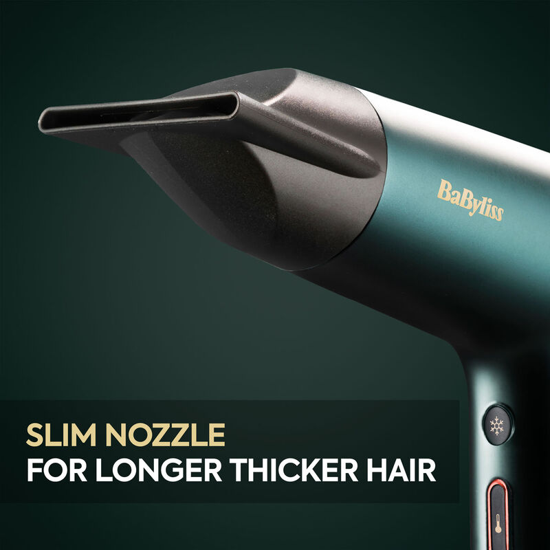 Nahaufnahme eines BaByliss Haartrockners mit schmaler Düse auf dunkelgrünem Hintergrund.