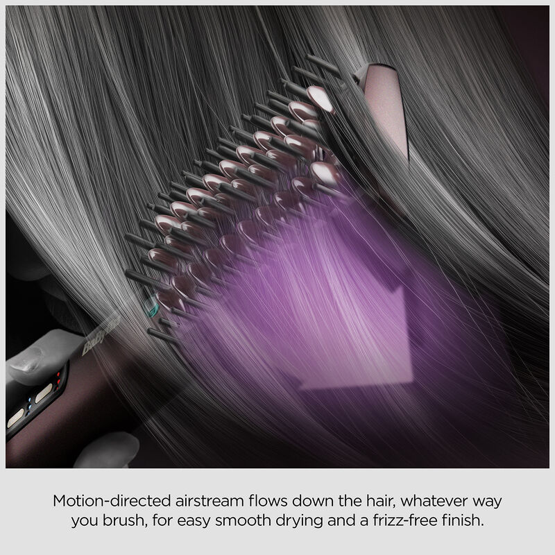 Une brosse coiffante lise les cheveux gris avec un flux d'air dirigé.