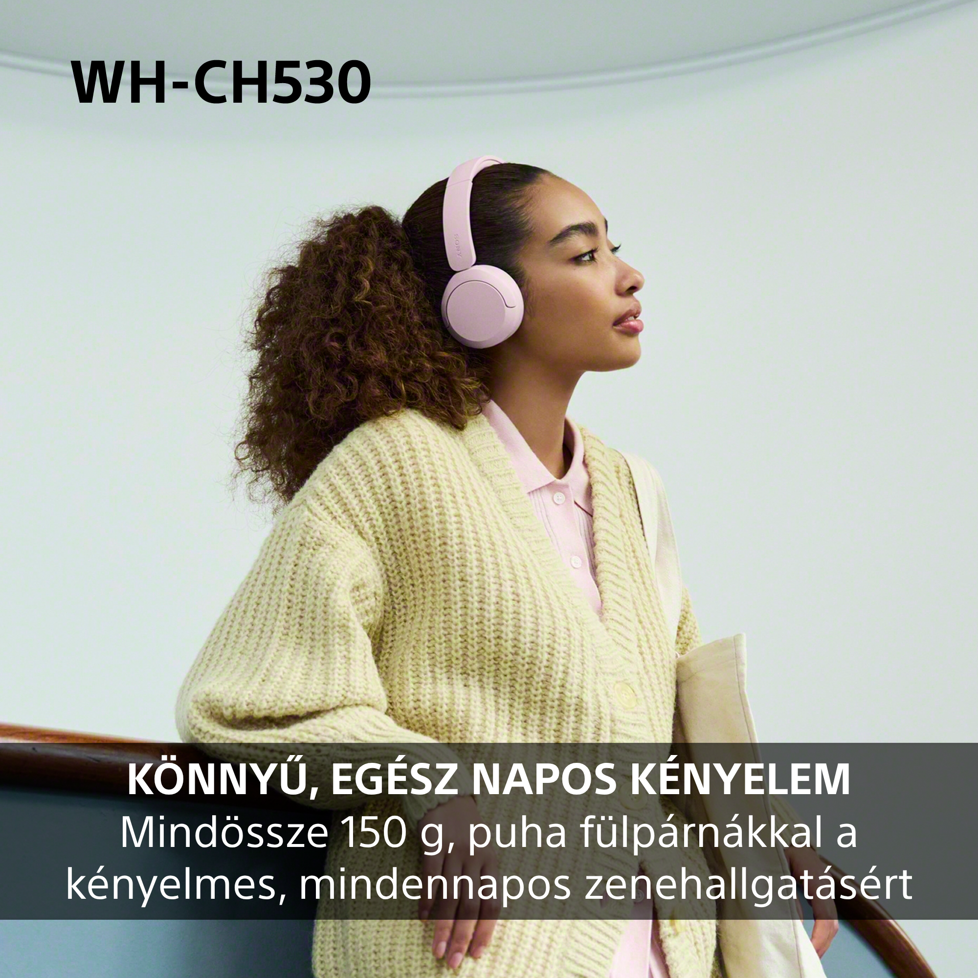 Egy rózsaszín fejhallgatót és krémszínű kardigánt viselő nő korlát mellett áll magyar szöveggel.
