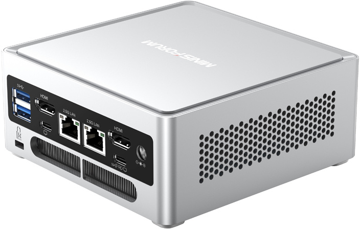 Ezüst színű mini PC szellőzőrácsokkal és különféle portokkal az elején.