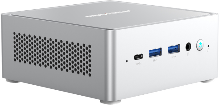 Ezüst színű mini PC elülső portokkal, USB-nyílásokkal és bekapcsológombbal fehér háttéren.