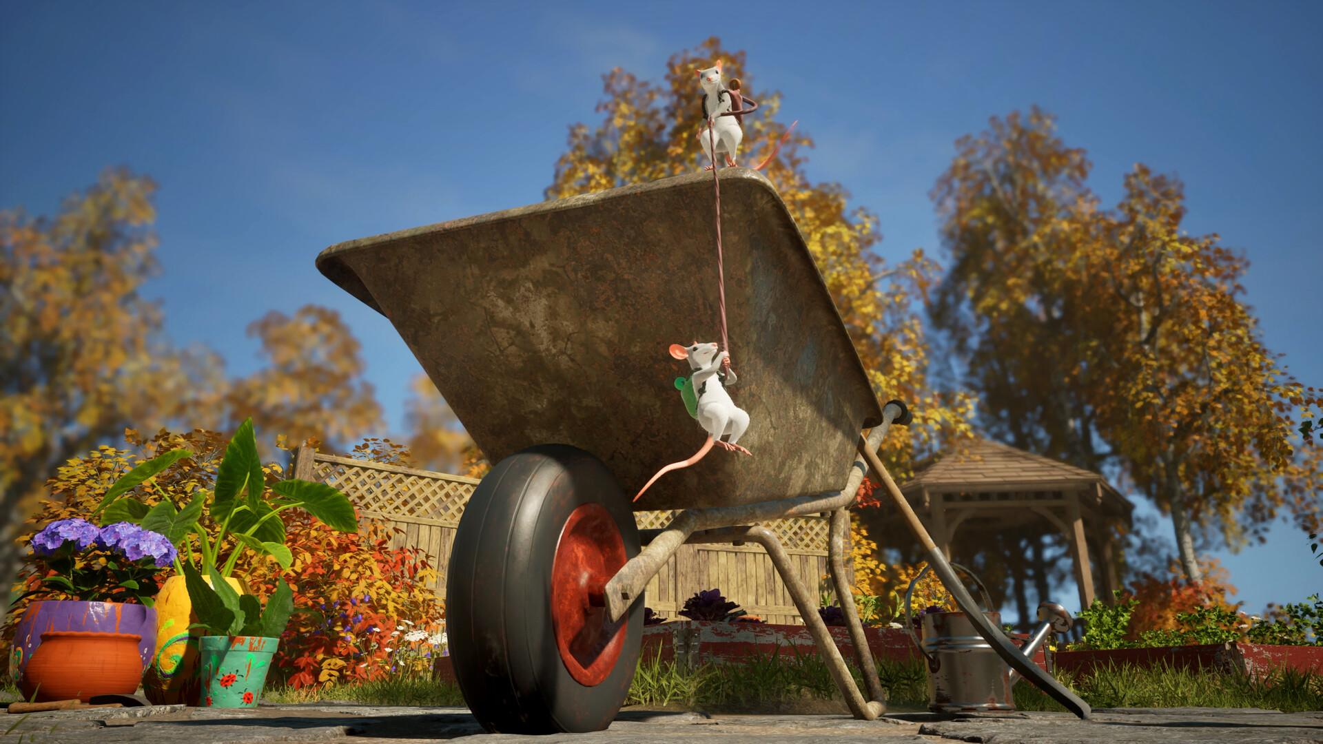 Zwei kleine weiße Mäuse spielen an einer rostigen Schubkarre in einem herbstlichen Garten mit blauem Himmel.