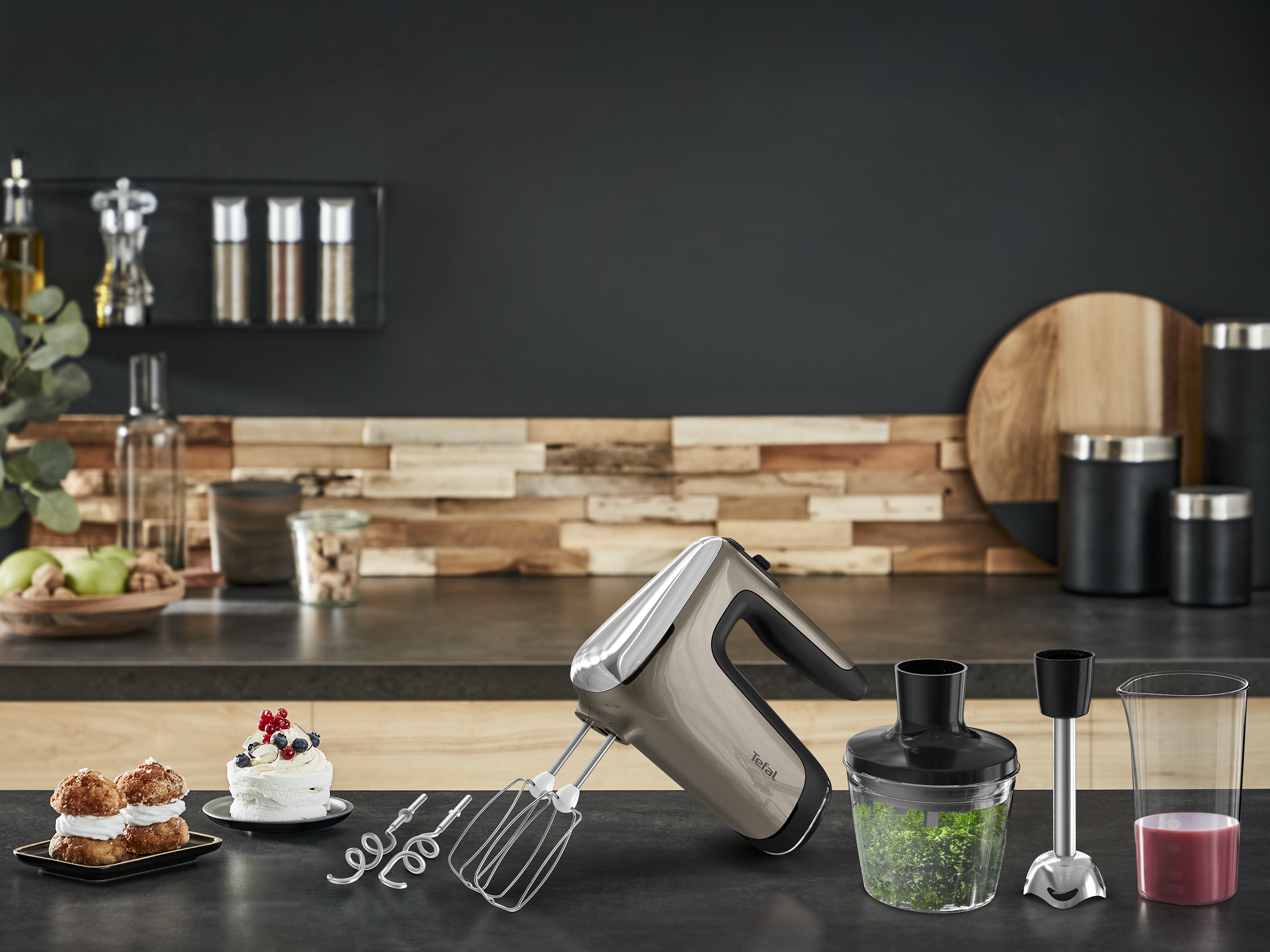 Tefal kézi mixer tartozékokkal és sütivel a konyhapulton.
