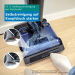 Staubsaugerkopf auf Holzboden mit Wassertank und zwei vergrößerten Einlagen, die die Selbstreinigung zeigen.