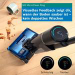 Ein Akkustaubsauger reinigt einen Holzboden mit Kaffeeflecken, daneben eine Tasse und Text über saubere Böden.