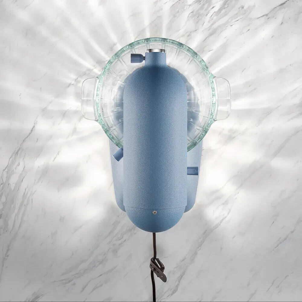 Eine Aufsicht auf ein blaues Küchengerät auf einer weißen Marmorarbeitsplatte mit strahlenden Lichtstrahlen.