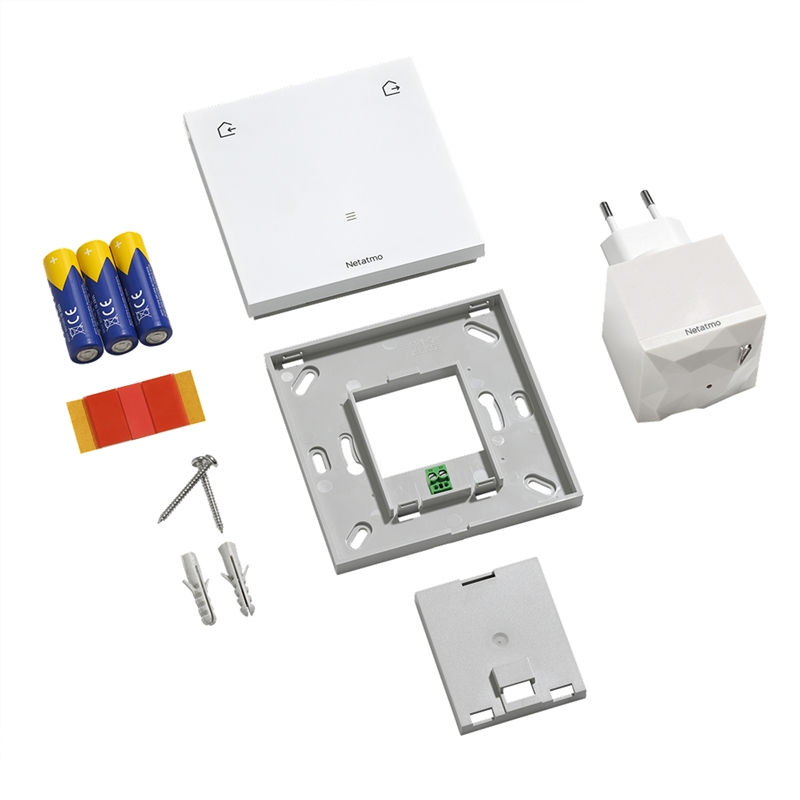 Piezas del dispositivo Netatmo: módulo blanco, soporte de pared, adaptador de corriente, tres pilas, adhesivos y tornillos.