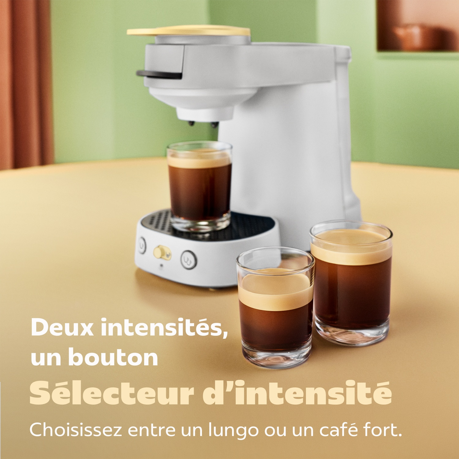 Une cafetière blanche avec trois verres de café frais sur une table sur fond vert.