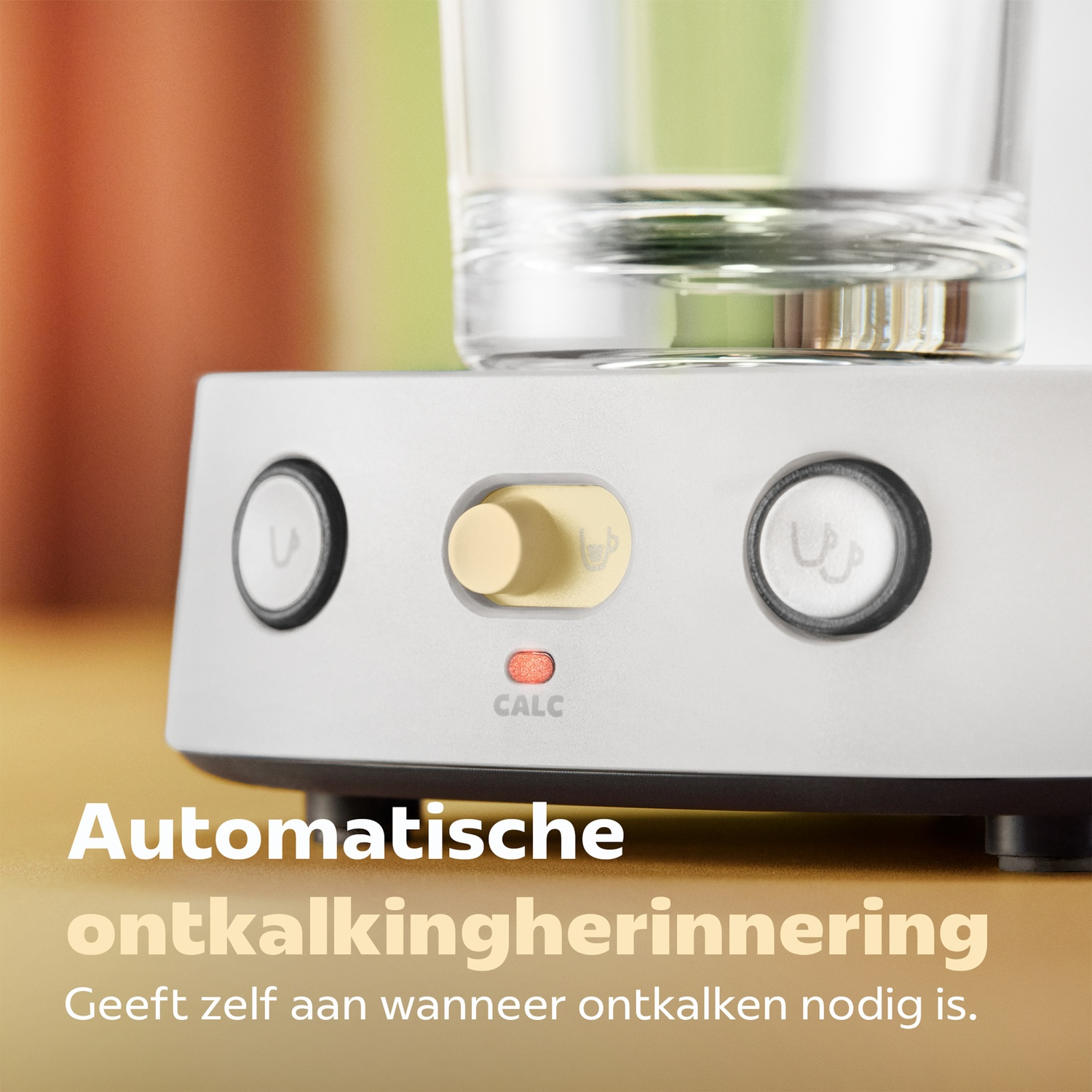 Koffiezetapparaat basis met twee knoppen, een draaiknop en een rode kalkindicatielampje onder een glas water.