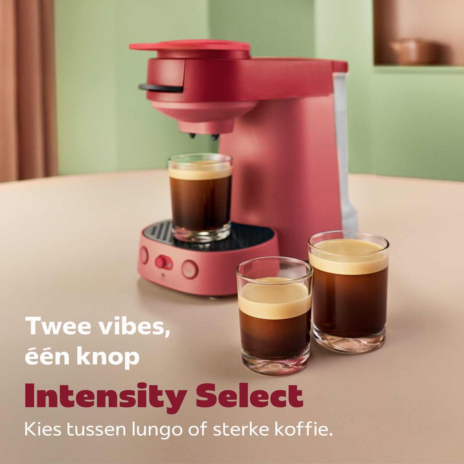 Een rode koffiezetapparaat op tafel met drie volle glazen koffie en tekst.