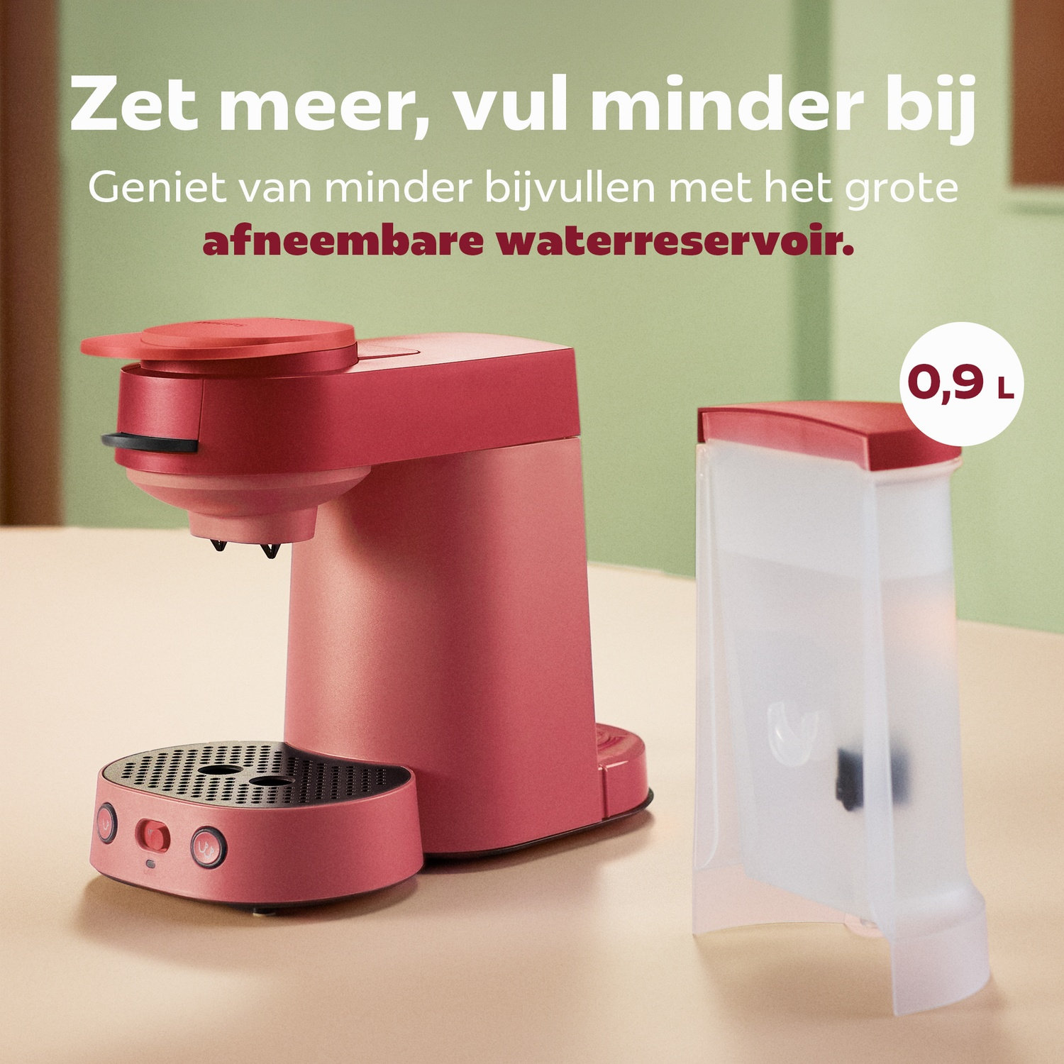 Rode koffiemachine met afneembaar waterreservoir van 0,9 liter op een licht oppervlak en groene achtergrond.