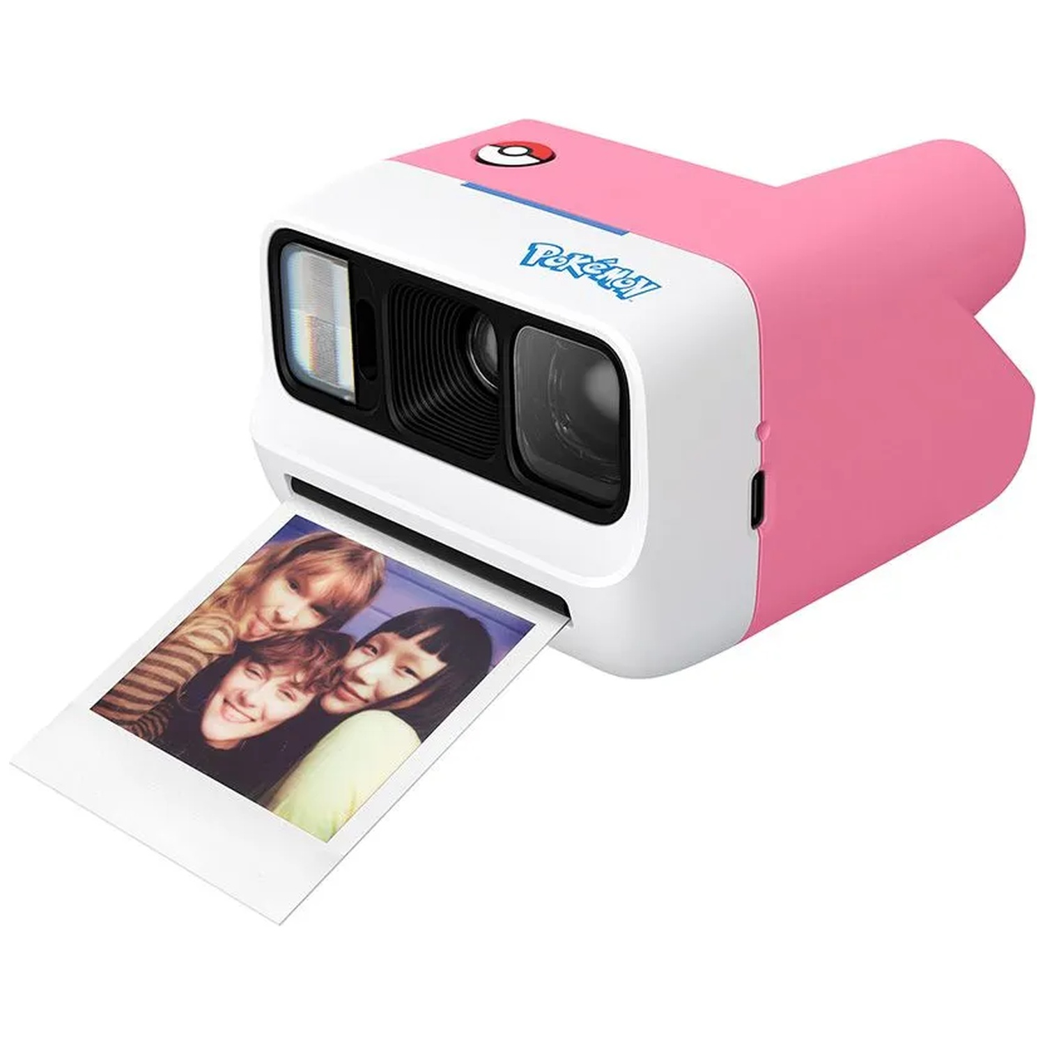 Un appareil photo instantané Pokémon rose et blanc imprime une photo de trois jeunes femmes souriantes.