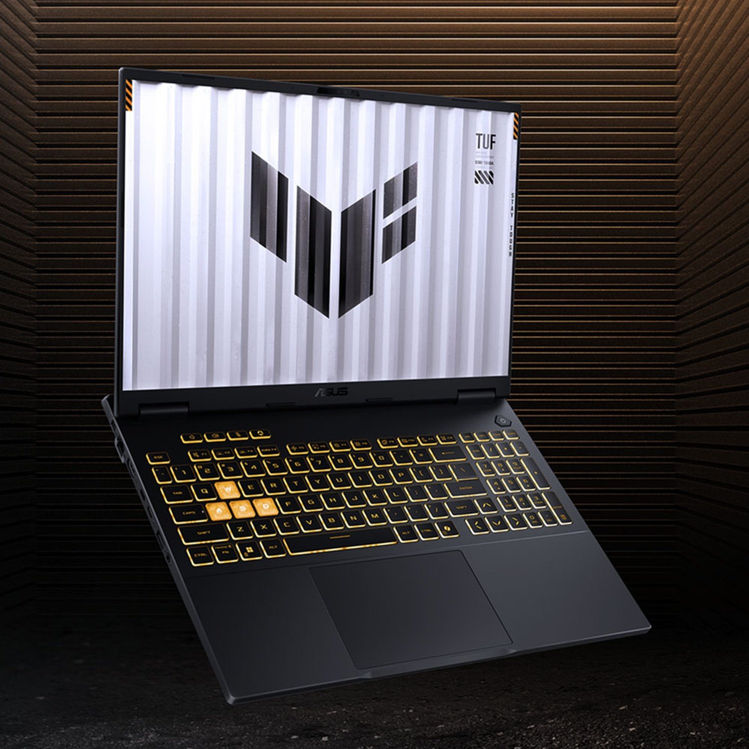 Een ASUS TUF-laptop met verlicht toetsenbord en logo op het scherm tegen een donkere achtergrond.
