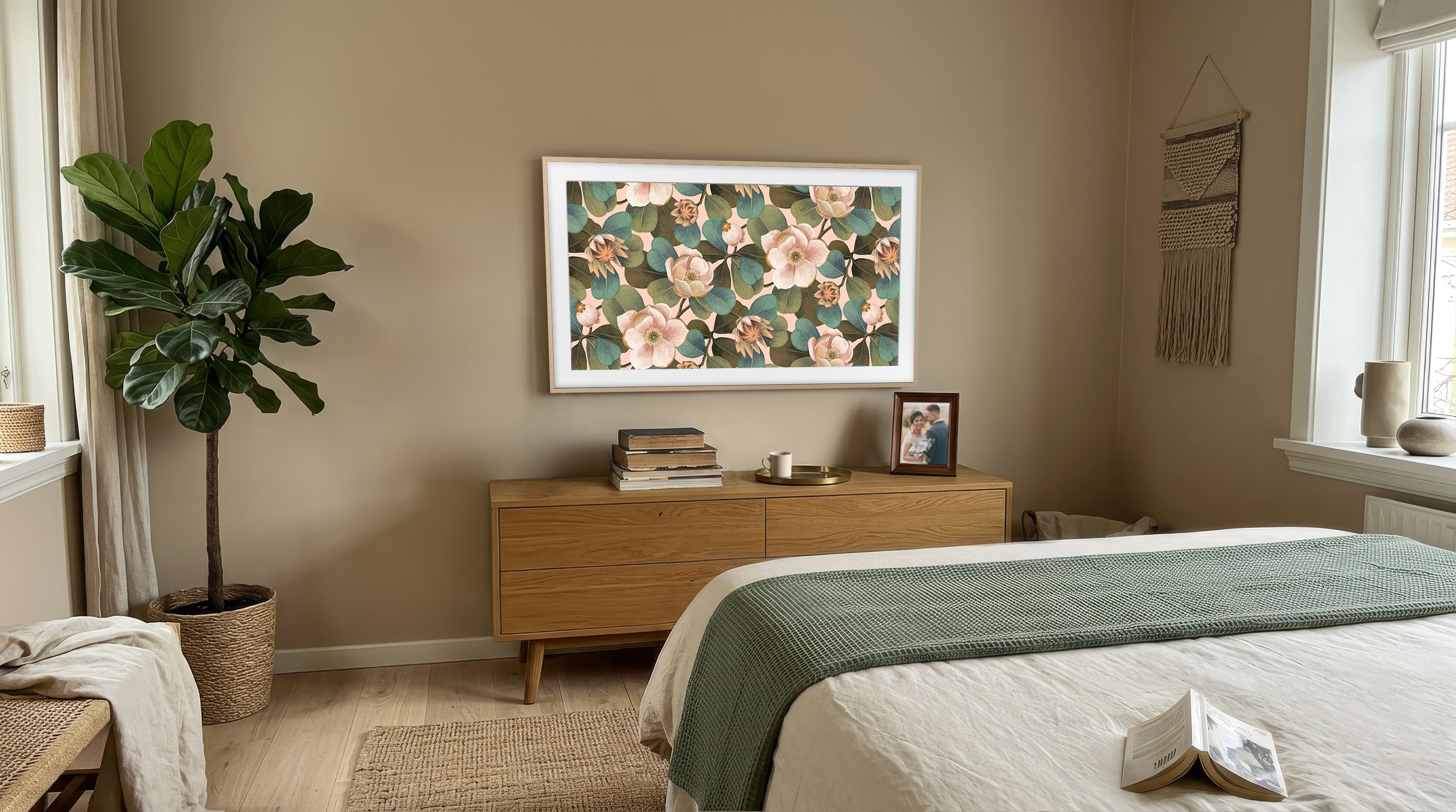 Dormitorio acogedor con cómoda de madera, gran arte floral en la tele, planta y cama.