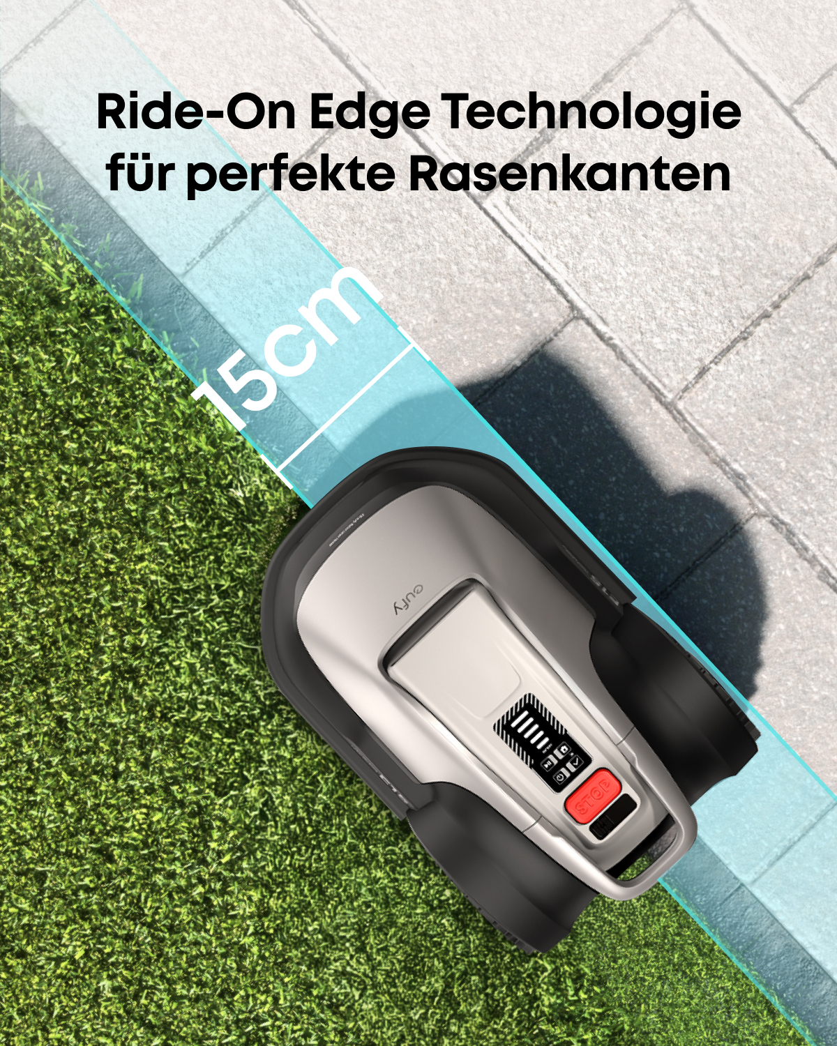Ein silberner Mähroboter steht auf einem Rasen und mäht präzise an einer Steinkante.