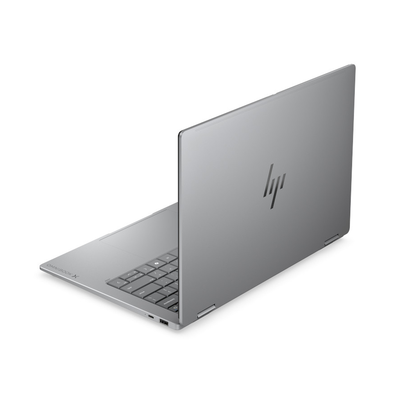 Un laptop HP OmniBook X argentato aperto su una superficie bianca, con la tastiera parzialmente visibile.