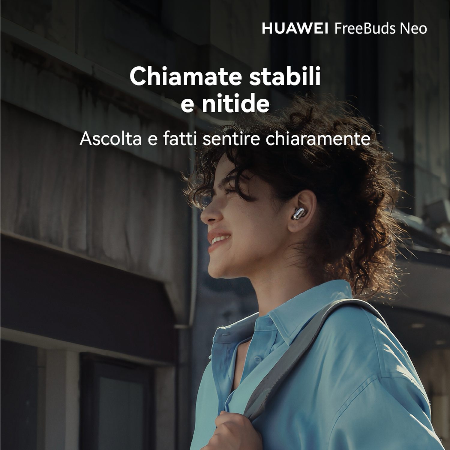 Una giovane donna sorridente con auricolari all'aperto.