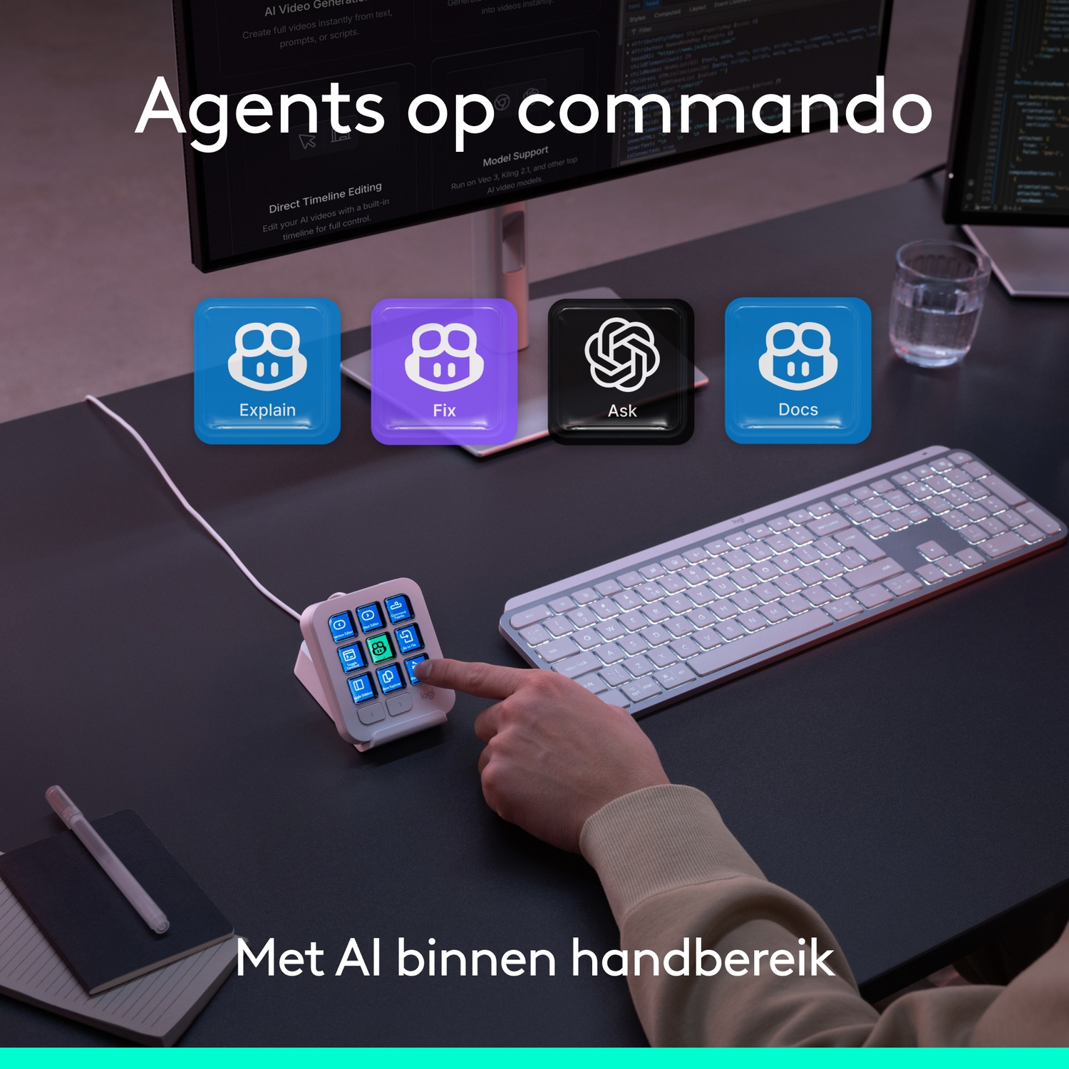 Een hand drukt op een knop op een klein sneltoetsenpad naast een toetsenbord en monitor.
