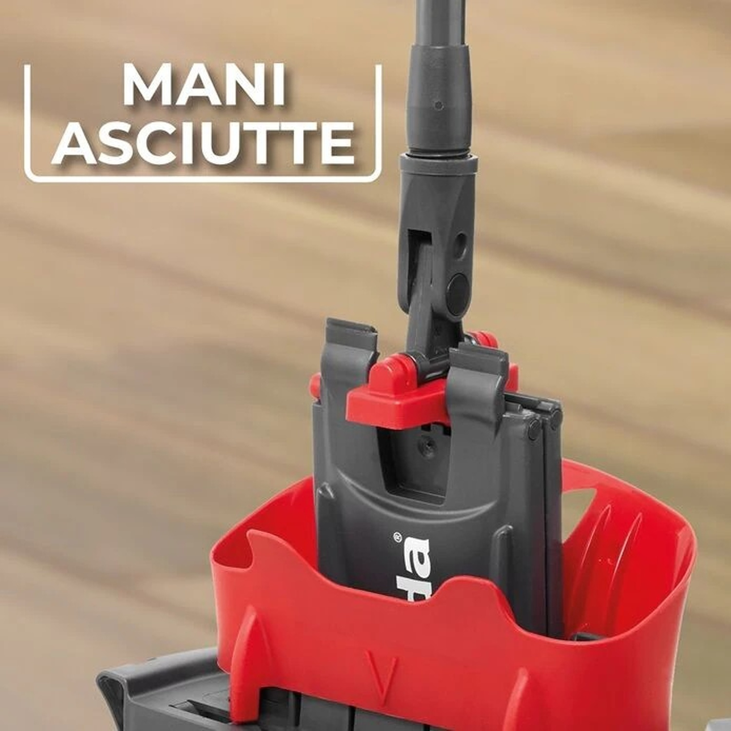 Un meccanismo di mocio grigio e rosso si trova in un secchio rosso su un pavimento in legno.