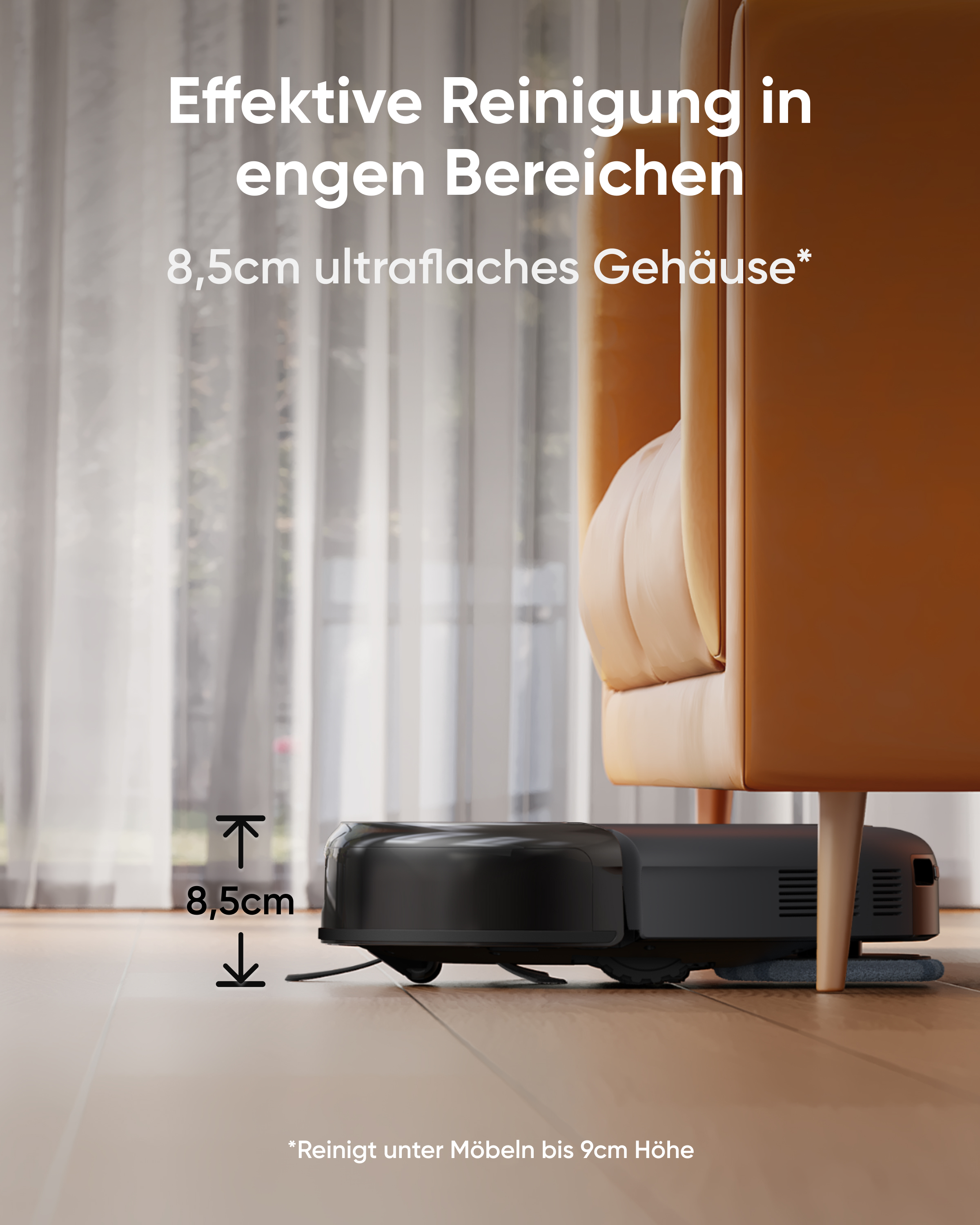 Ein schwarzer Saugroboter reinigt unter einem orangefarbenen Sessel auf einem Holzboden.