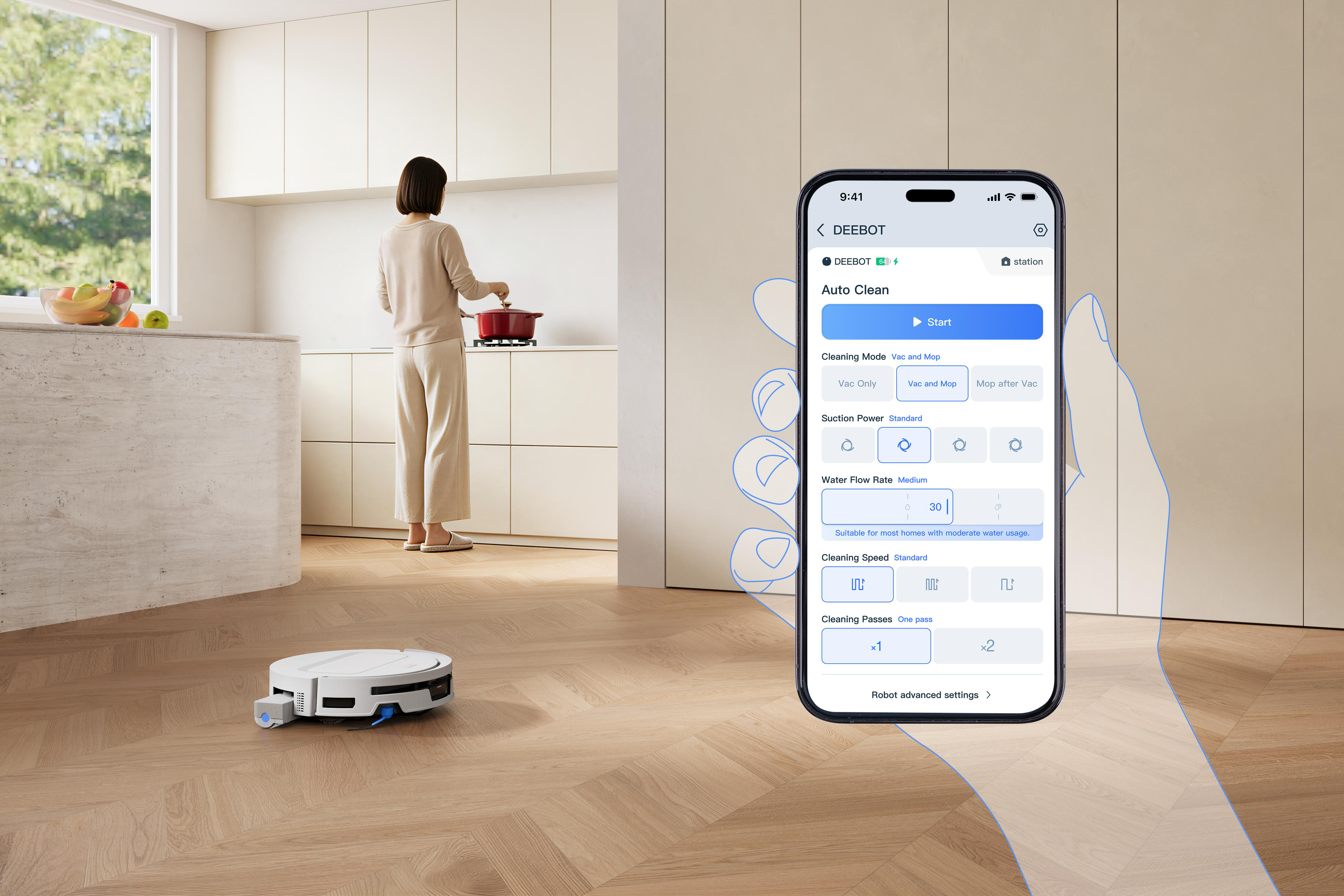 Smartphone zeigt Steuerungsapp für einen Saugroboter in einer modernen Küche mit kochender Frau.