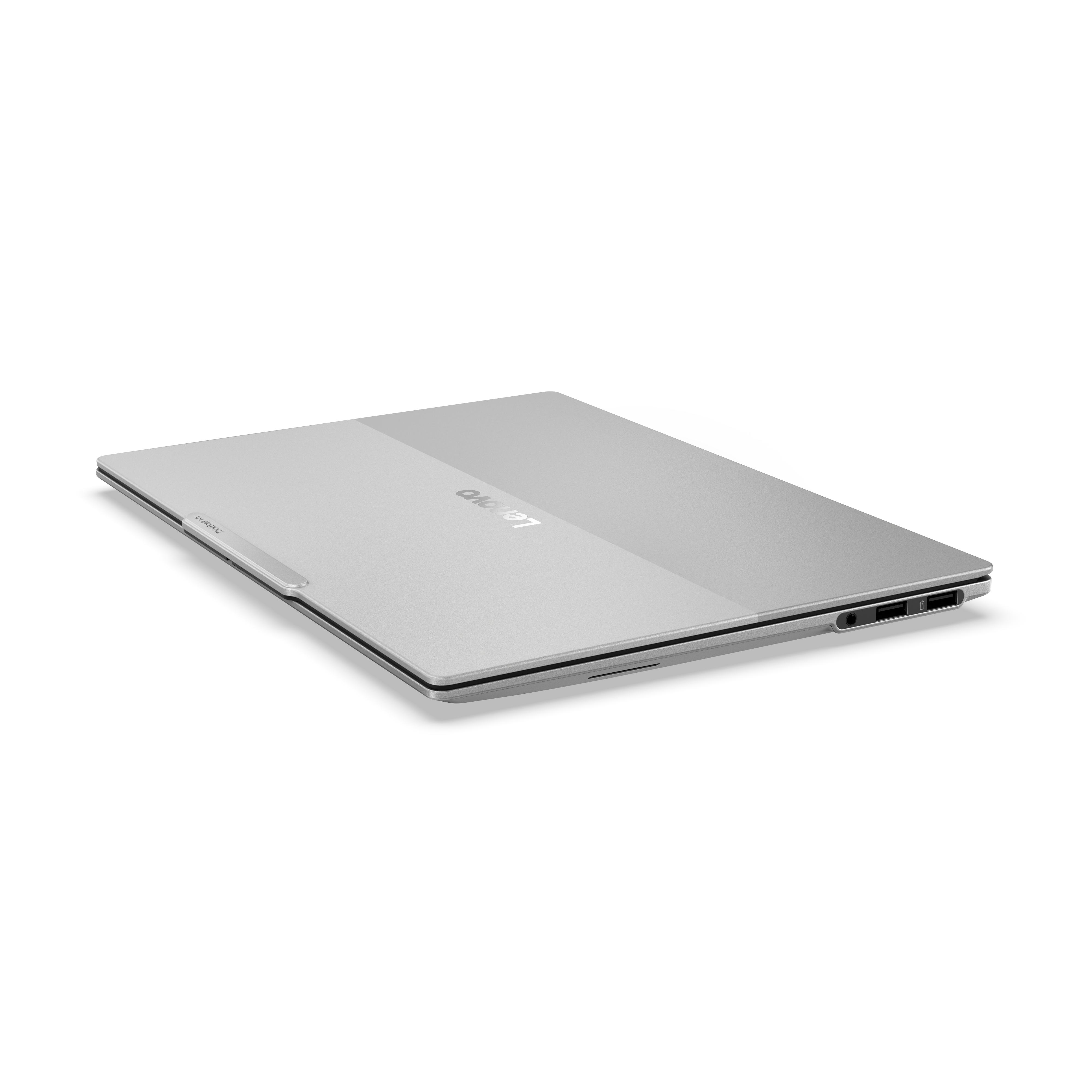 Ein silberner geschlossener Lenovo Laptop liegt auf einer weißen Oberfl äche mit sichtbarem Logo und Anschlüssen.