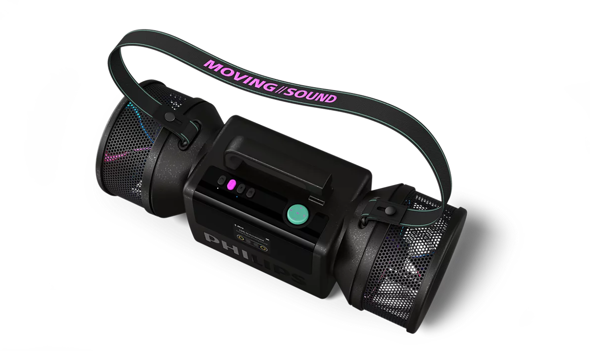 Egy fekete Philips hordozható hangszóró MOVING SOUND feliratú pánttal, sötét háttér előtt.
