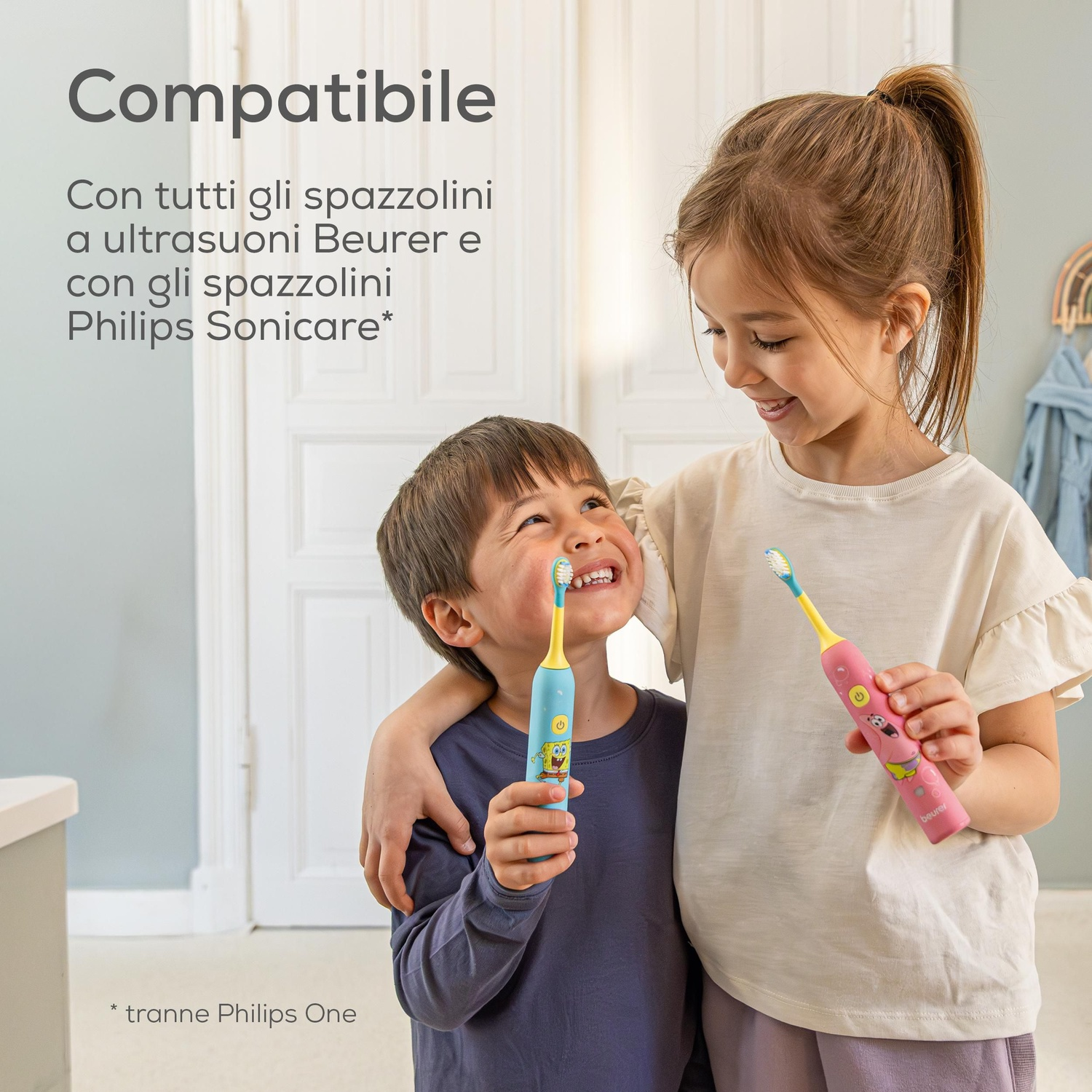 Una bambina e un bambino sorridono felici tenendo spazzolini elettrici colorati.