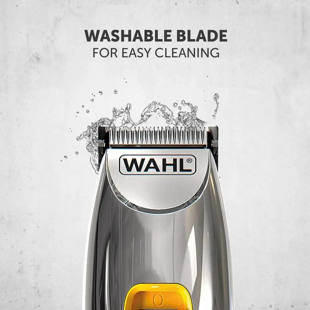 Nahaufnahme eines silbernen Wahl-Haarschneiders mit abwaschbarer Klinge und Wasserspritzern vor grauer Wand.