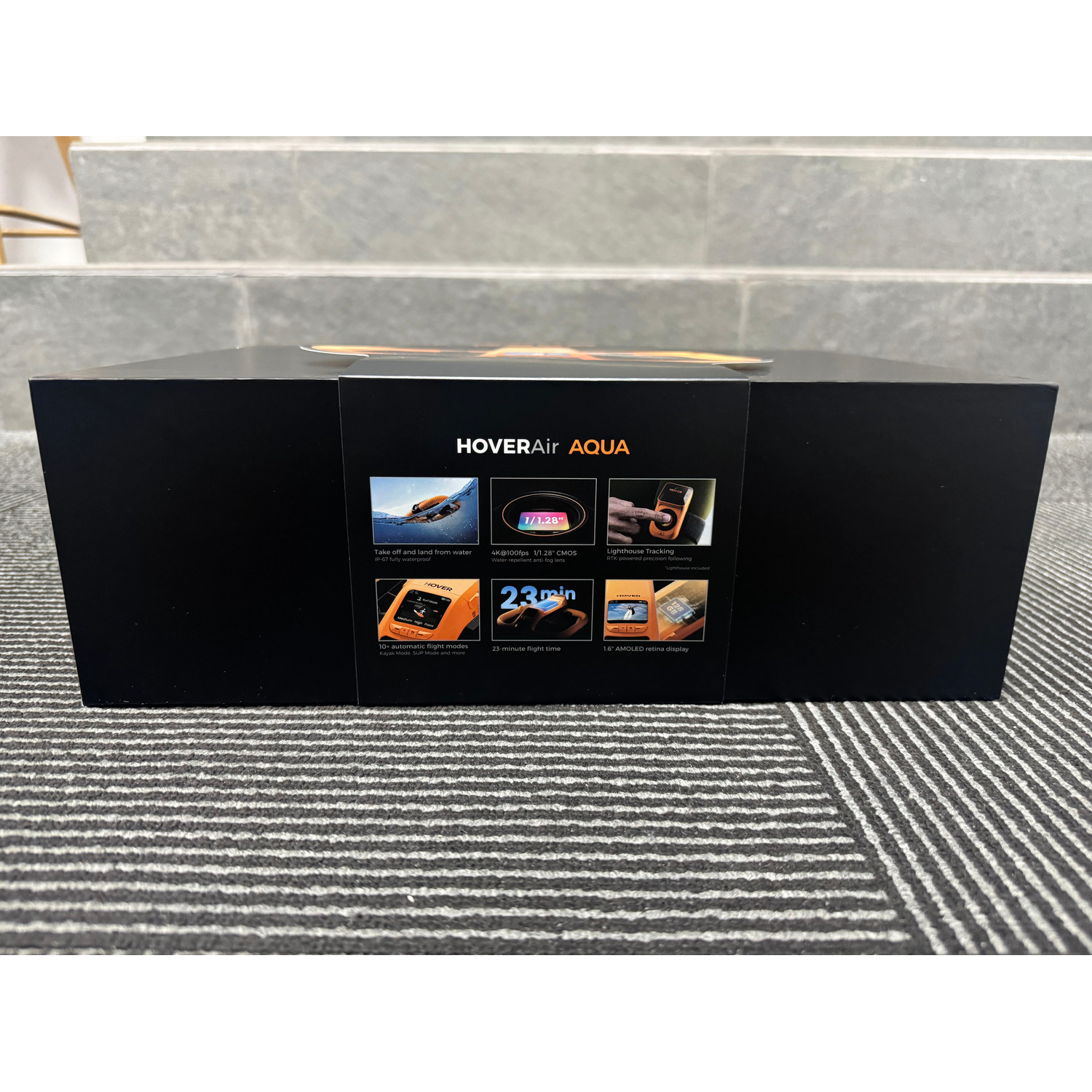 Scatola del prodotto nera HoverAir Aqua con immagini e specifiche sul pannello frontale.