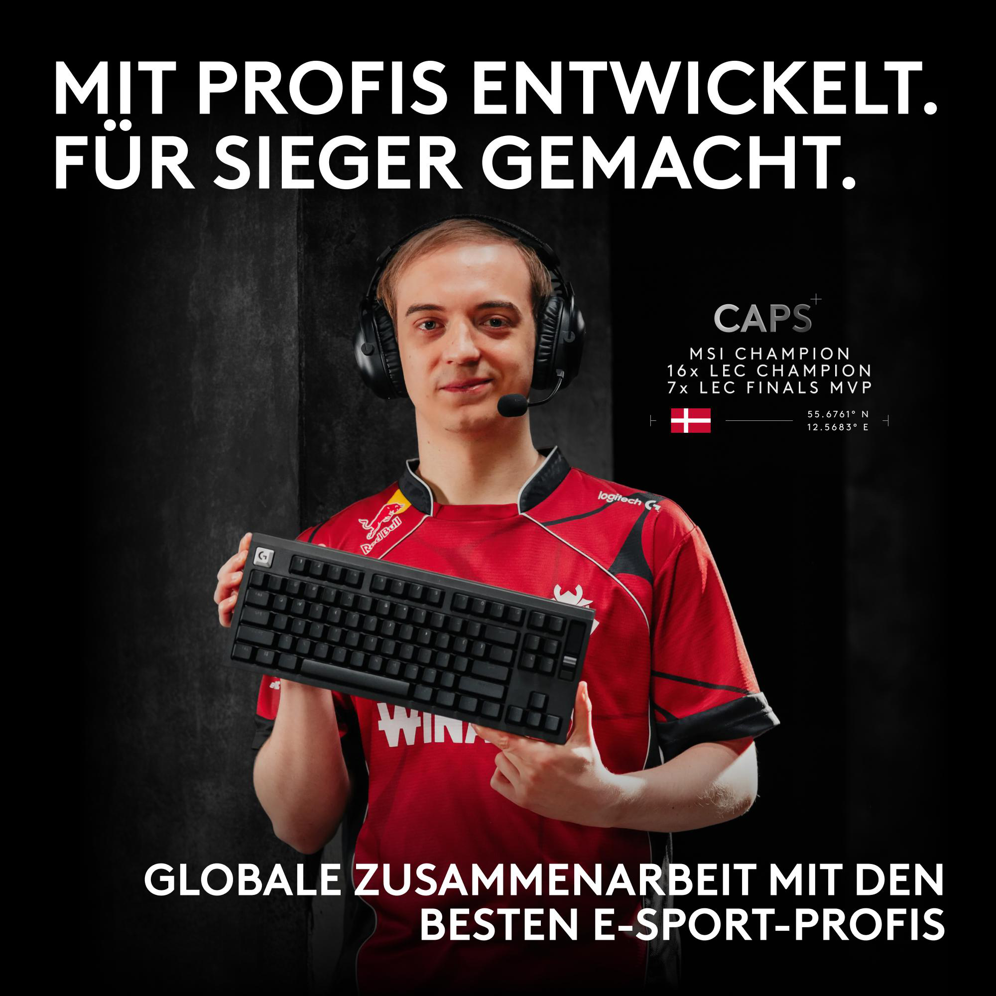 E-Sportler Caps hält eine schwarze Tastatur, flankiert von deutschem Text und dem dänischen Banner.