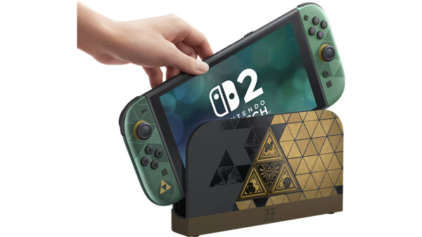Ręka umieszcza zieloną konsolę Nintendo Switch z motywem Zeld w pasującej stacji dokującej.