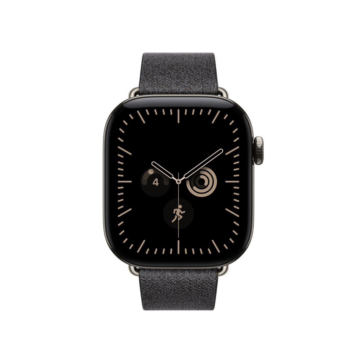 Eine schwarze Smartwatch mit grauem Stoffarmband und analogen Zifferblattdetails vor weißem Hintergrund.