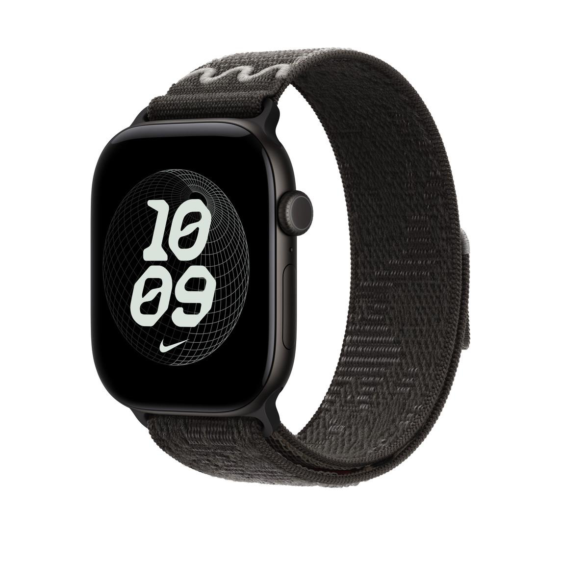 Eine schwarze Smartwatch mit dunkelgrauem Textilarmband zeigt das digitale Zifferblatt 10:09 gegen weißen Hintergrund.