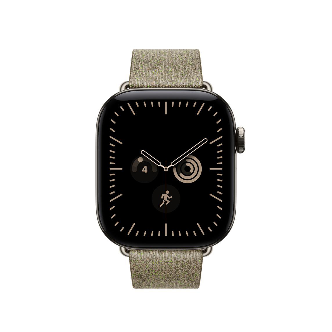 Eine schwarze Smartwatch mit Textilarmband zeigt ein Zifferblatt mit Komplikationen auf weißem Hintergrund.