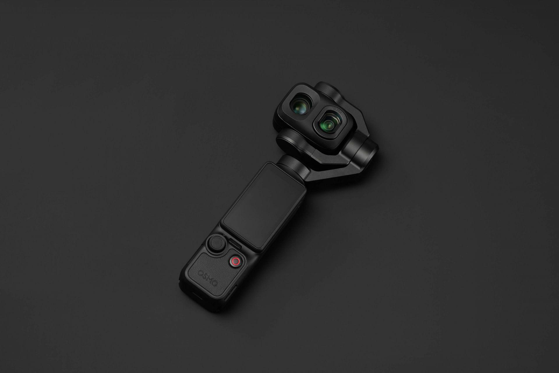 Eine schwarze DJI Osmo Action-Kamera liegt auf einem dunklen Hintergrund und zeigt zwei Linsen und das Display.