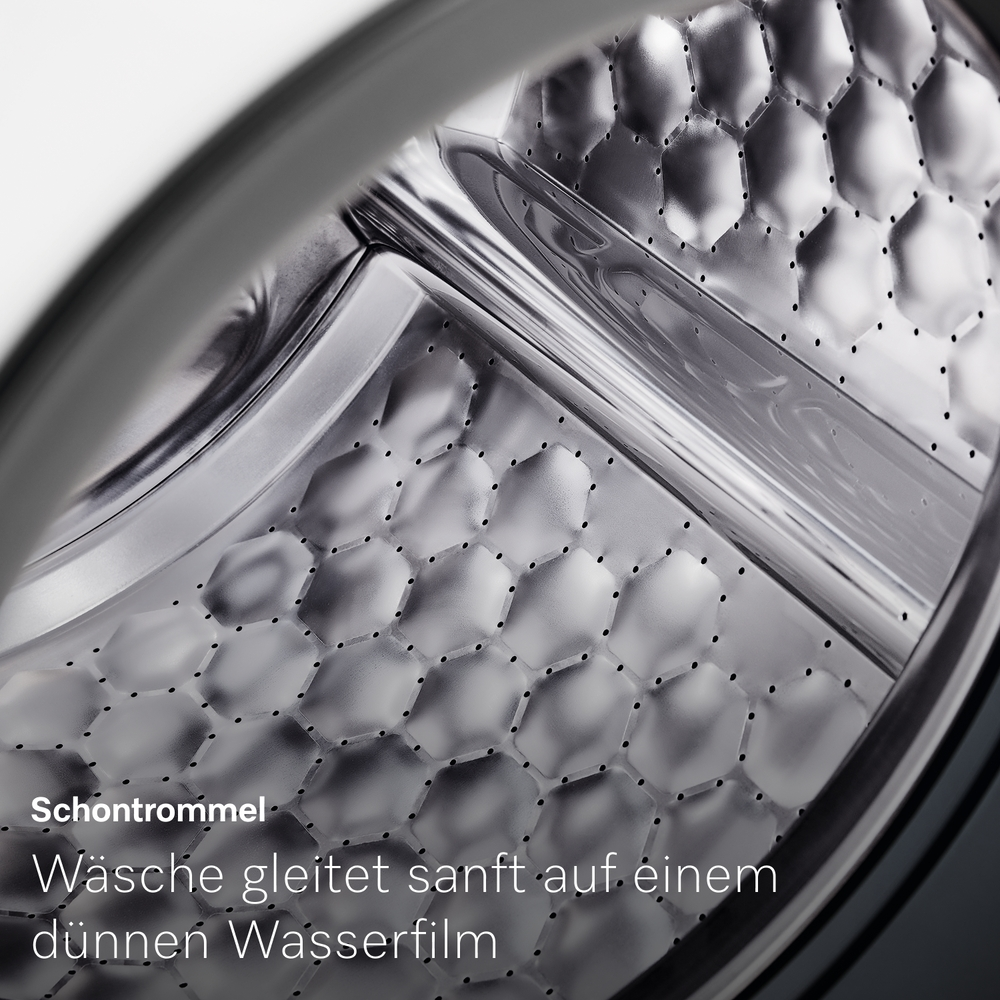 Nahaufnahme der Edelstahl-Schontrommel einer Waschmaschine mit Wabenstruktur.