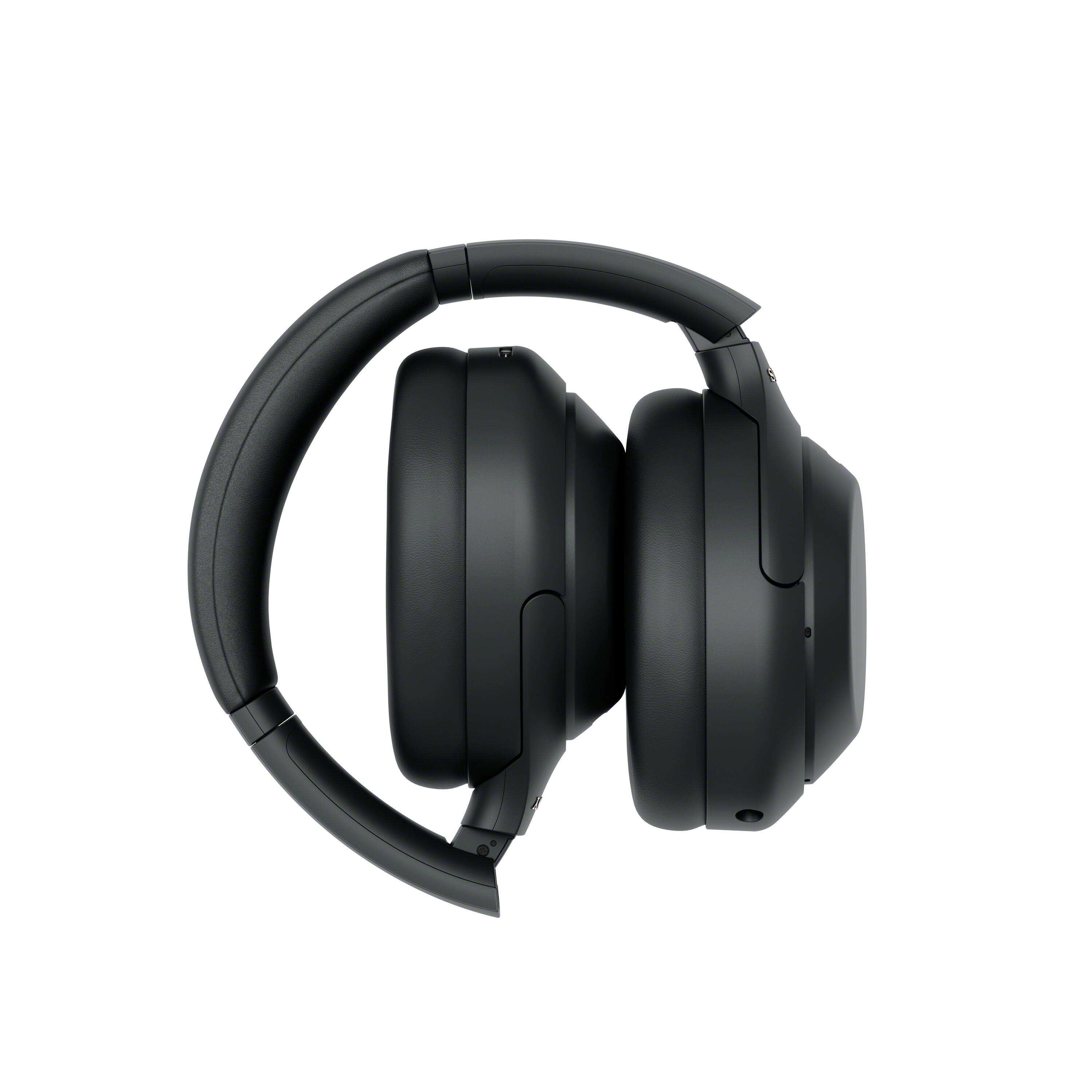 Auriculares supraurales negros plegados sobre un fondo blanco.