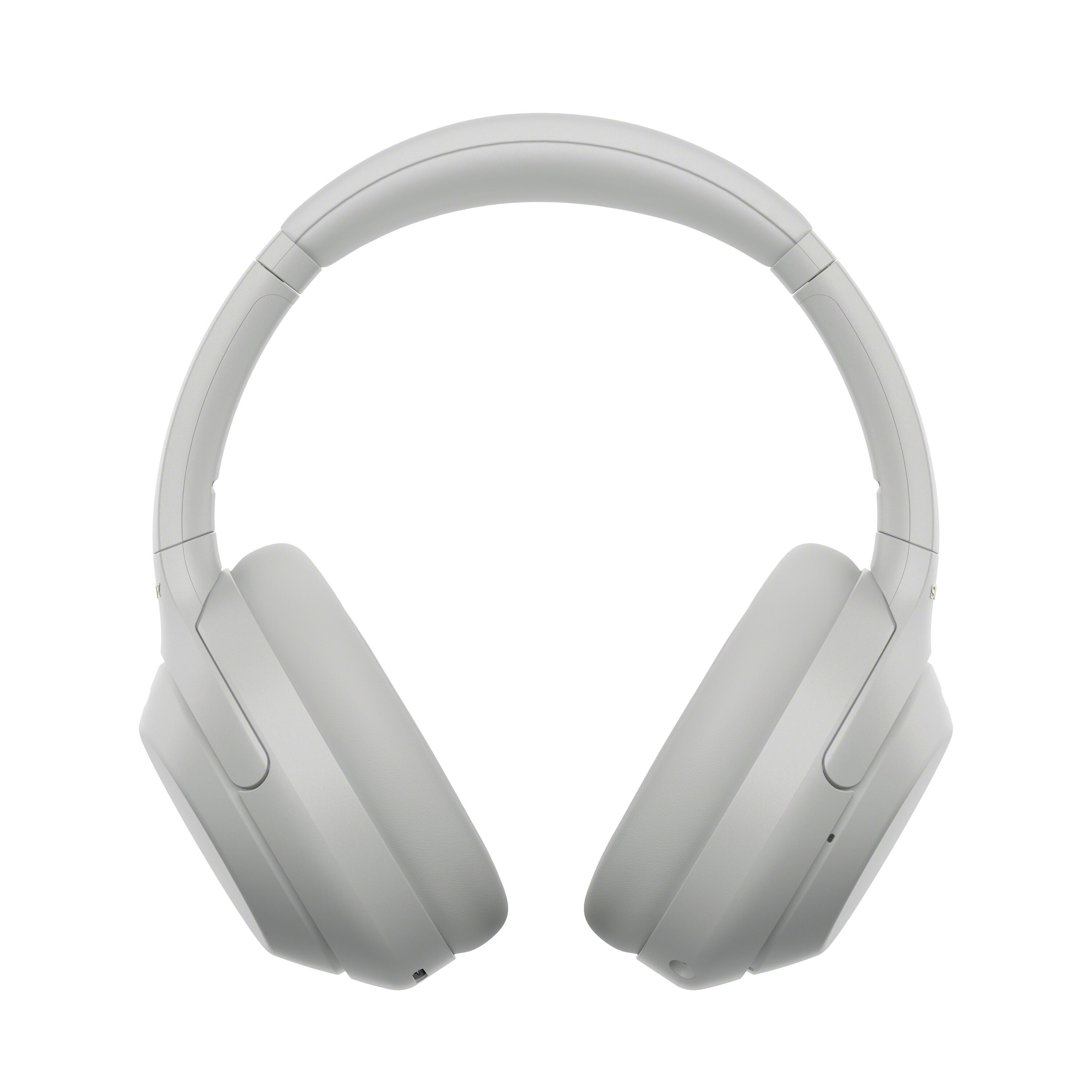 Un par de auriculares inalámbrícos circumaurales en gris claro sobre fondo blanco.