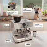 Silberne Espressomaschine mit Messungen und Insets im Hintergrund einer Küche.