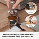 Ein Metalldtamper presst Kaffeemehl in einen Siebträger, mit zwei Detailkreisen und deutschem Text unten.