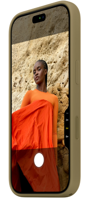 Smartfon w oliwkowym etui wyświetla na ekranie kobietę w pomarańczowym ubraniu na tle skał.