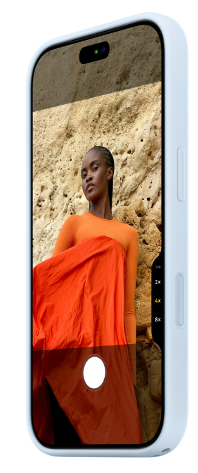 Smartfon w niebieskim etui wyświetla zdjęcie kobiety w pomarańczowym ubraniu na tle skalnej ściany.