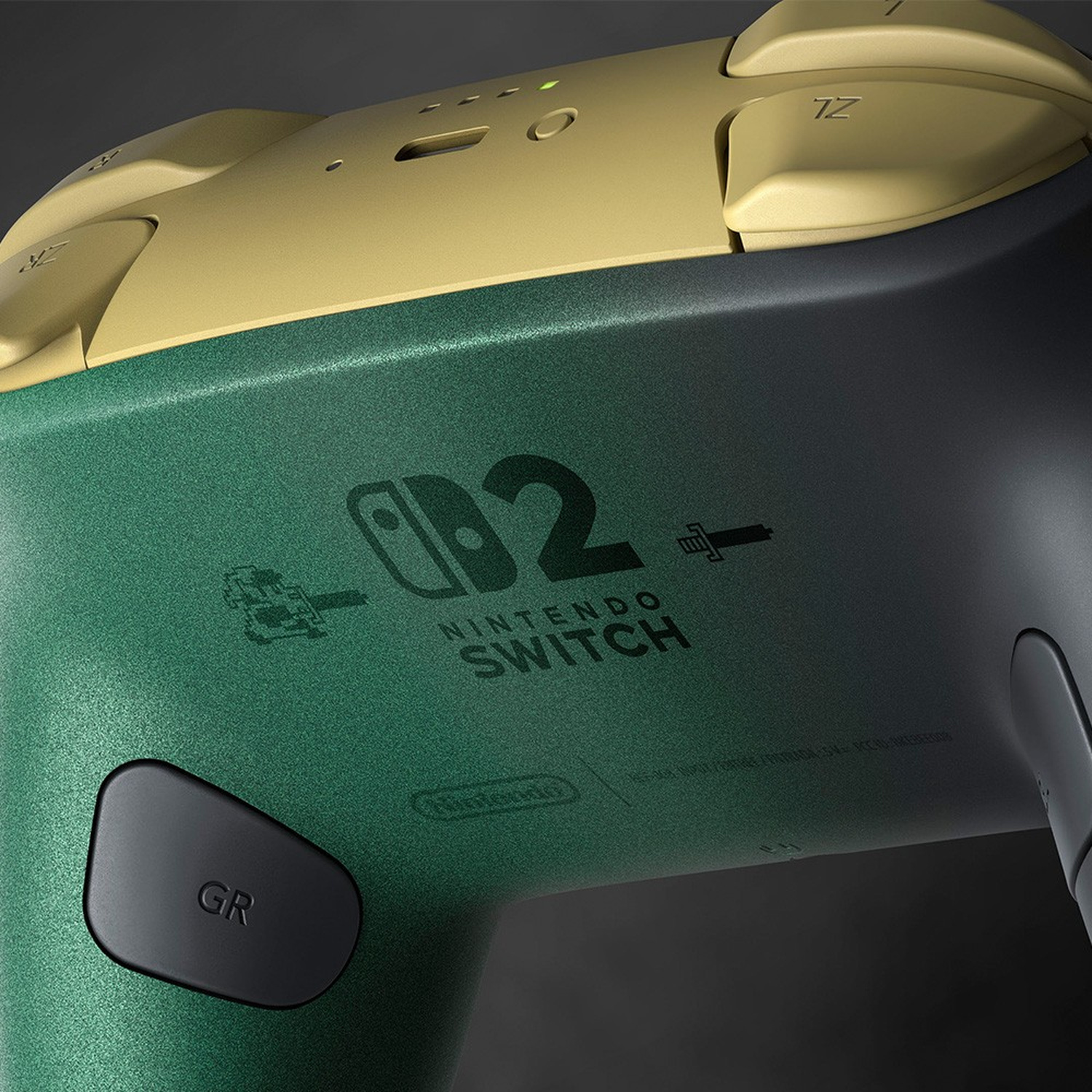 Primo piano di un controller verde e nero per Nintendo Switch 2 con grilletti dorati e un pulsante GR nero.