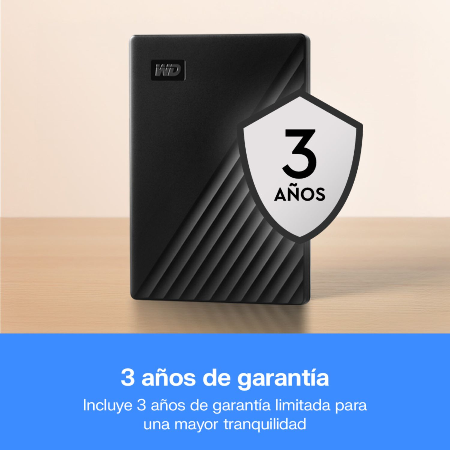 Un disco duro externo WD negro sobre una mesa con insignia de 3 años de garantía.