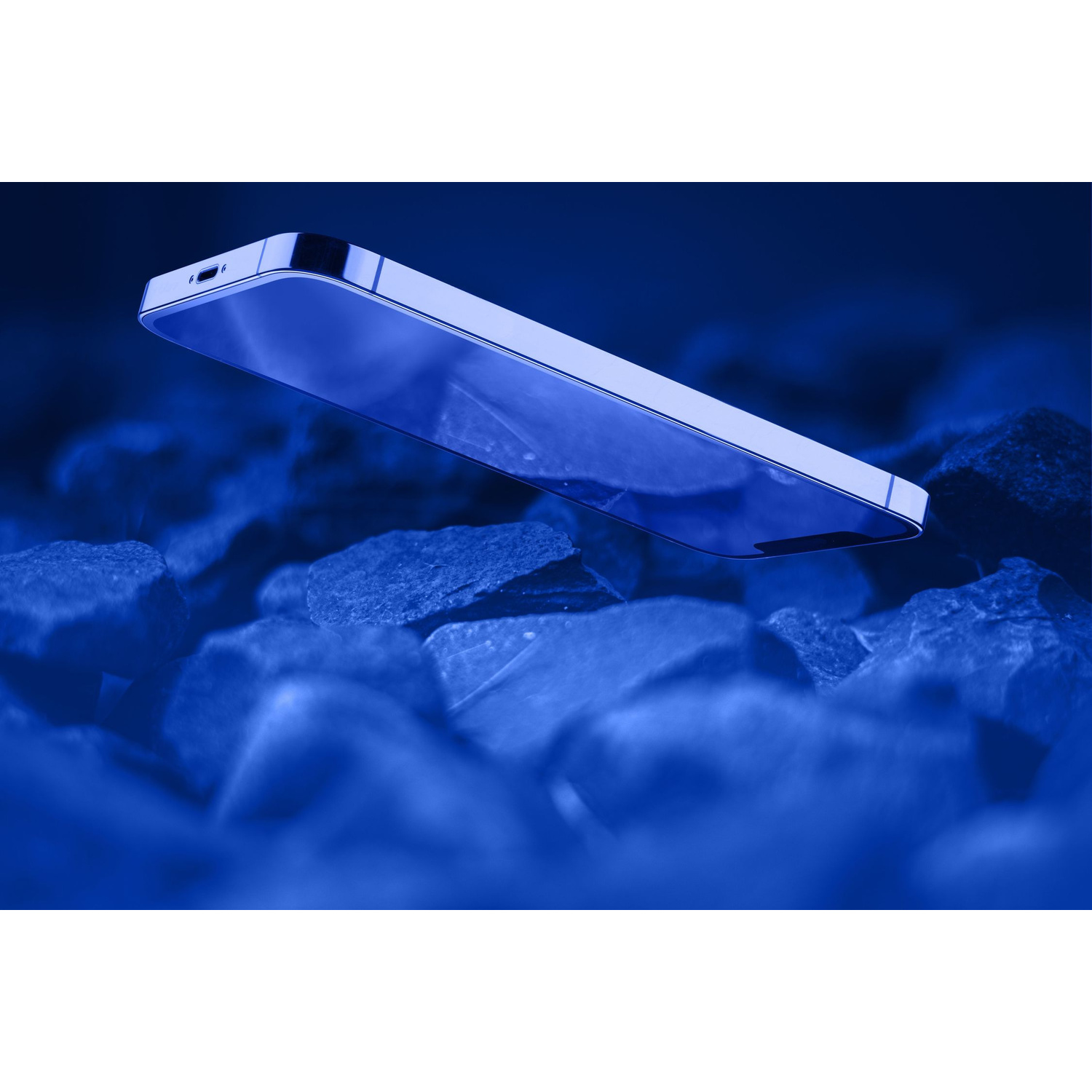 Uno smartphone fluttua sopra rocce scure su sfondo blu.