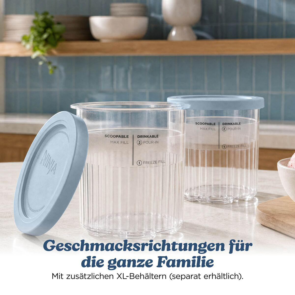 Zwei transparente Behälter mit blauen Deckeln stehen auf einer Küchenarbeitsplatte.