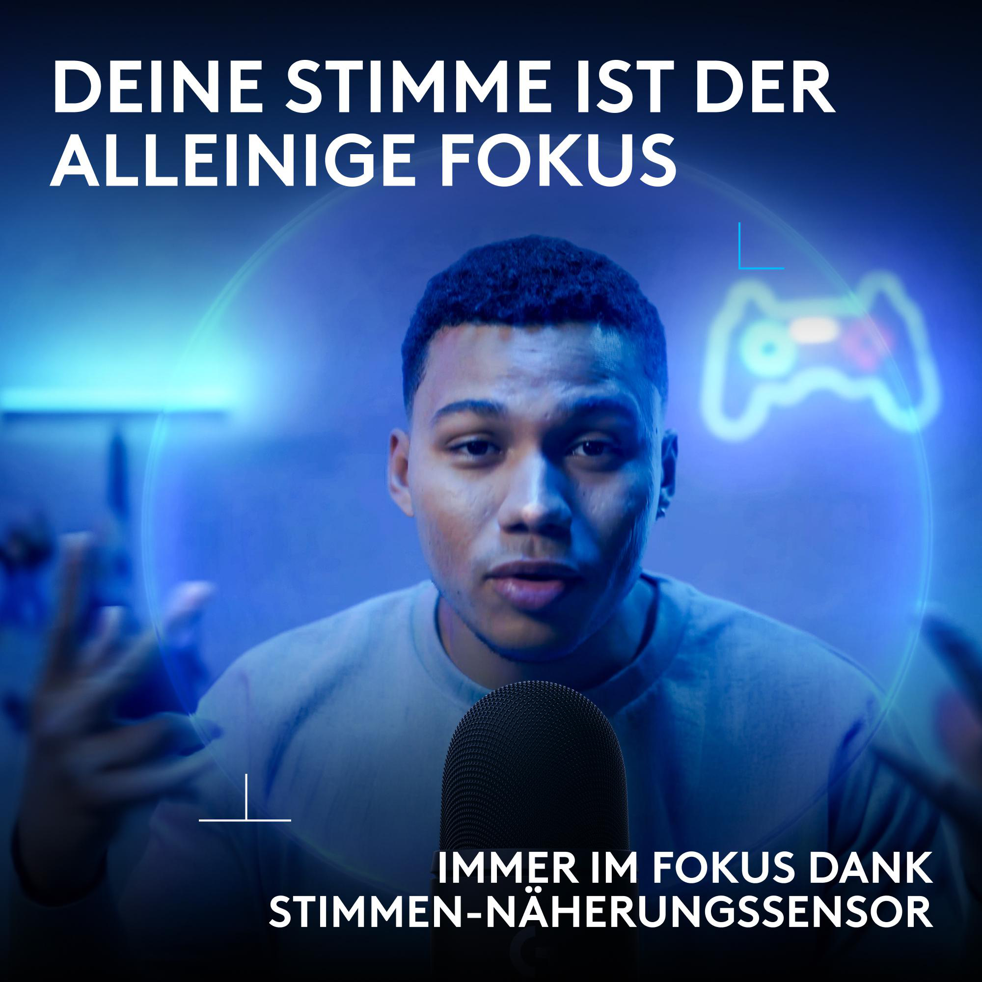 Ein junger Mann spricht in ein Mikrofon, umgeben von blauem Licht und Gaming-Dekor.