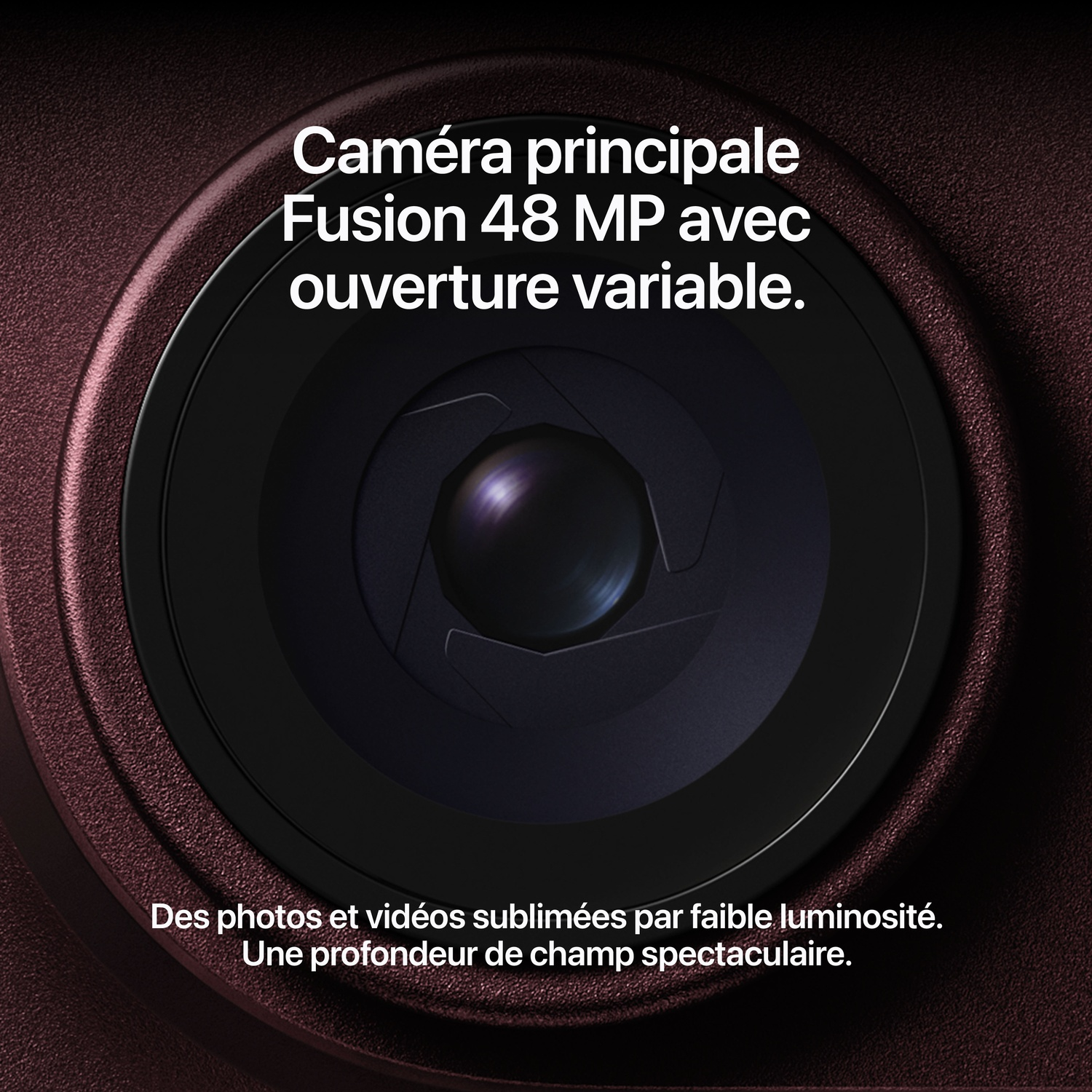 Gros plan sur un objectif de caméra de smartphone entouré de métal rouge foncé avec du texte.
